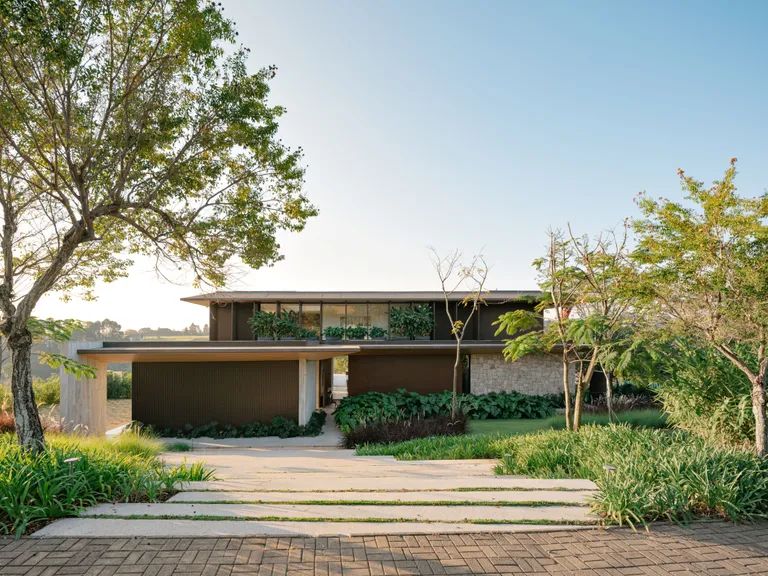 Fachada de uma casa contemporânea cercada por jardim